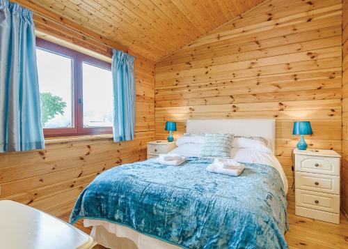 a bedroom with a bed in a wooden cabin at Trewythen Lodges in Caersws