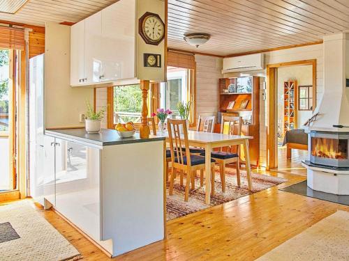 a kitchen and dining room with a table and a clock at 7 person holiday home in VÄRMDÖ-By Traum in Värmdö