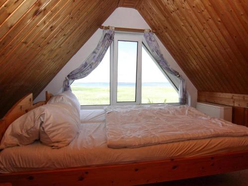 a bed in a room with a window at Wunderschönes Ferienhaus am Schilfufer in Barth in Barth