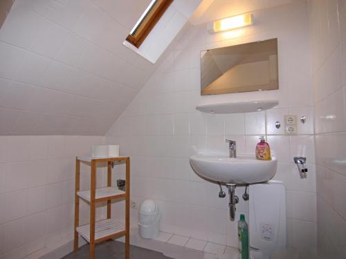 une salle de bain blanche avec un lavabo et un miroir dans l'établissement Cozy Holiday Apartment on Fehmarn, à Petersdorf auf Fehmarn