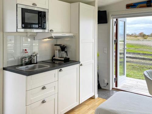 a kitchen with white cabinets and a sink and a window at 3 person holiday home in LÖTTORP-By Traum in Löttorp