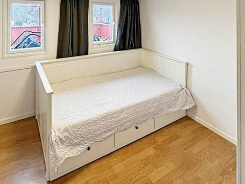 a white bed in a room with two windows at 4 person holiday home in Södertälje-By Traum in Södertälje