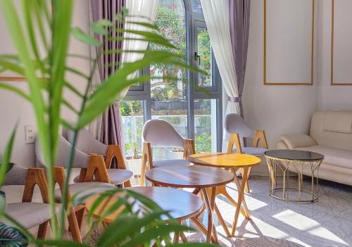 a living room with tables and chairs and a couch at Pham Gia Dalat Villa & Hotel in Da Lat