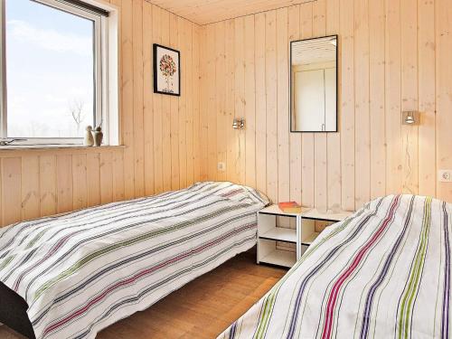 a bedroom with two beds and a mirror and a window at 20 person holiday home in Hasselberg in Kappeln