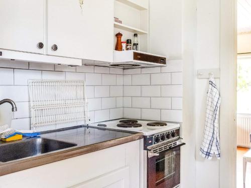 a white kitchen with a sink and a stove at 5 person holiday home in FLEN-By Traum in Flen