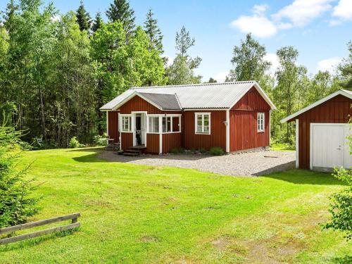 a red barn with a garage in a yard at 8 person holiday home in SKÅNES FAGERHULT-By Traum in Skånes Fagerhult