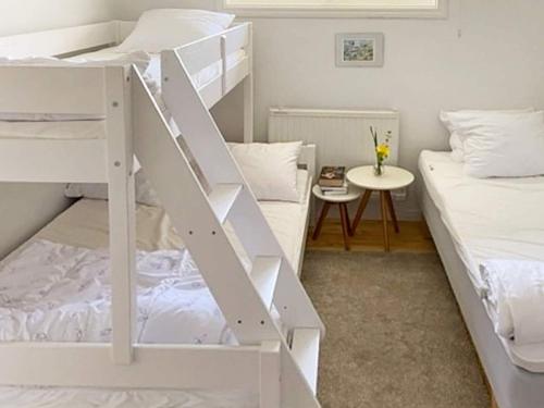 a dorm room with two bunk beds and a table at 5 person holiday home in STRÄNGNÄS-By Traum in Strängnäs