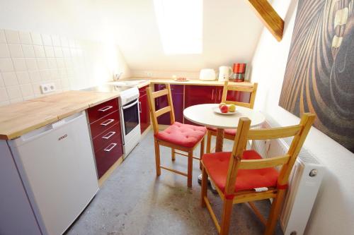 a small kitchen with a small table and chairs at Villa am Schwanenteich in Spremberg