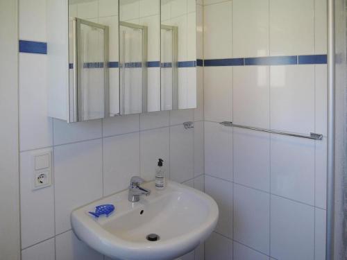 Un baño blanco con lavabo y espejo. en Ferienhaus in Burhave, en Burhave