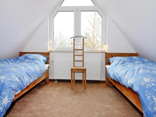a bedroom with two beds and a ladder next to a window at Haus in Vieregge am Breetzer Bodden in Vieregge