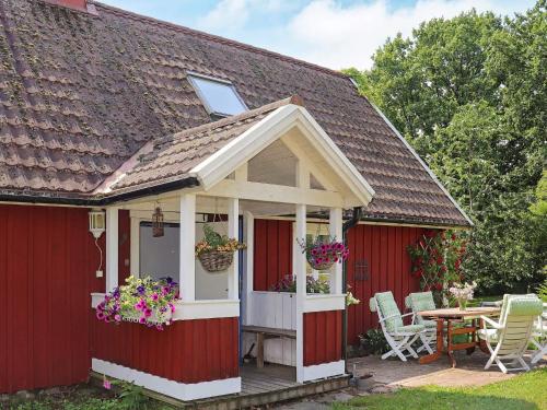 a red shed with a white door and a table at 6 person holiday home in ÖRKELJUNGA in Orkelljunga