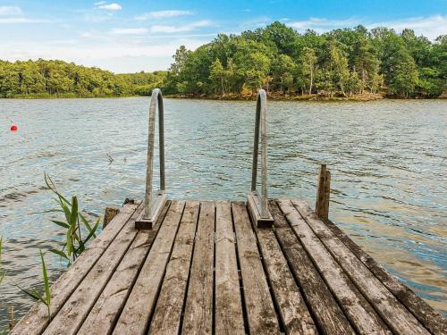 a dock on a body of water with trees at 3 person holiday home in FLEN-By Traum in Flen