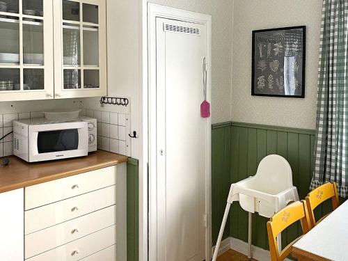 a kitchen with green and white cabinets and a microwave at 5 person holiday home in STAVSJÖ-By Traum in Stavsjo