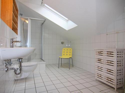 a bathroom with a sink and a yellow chair at Holiday Complex Orther Reede Fehmarn in Orth
