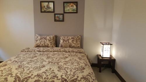 sypialnia z łóżkiem i 2 zdjęciami na ścianie w obiekcie Old City Boutique House w mieście Sukhothai