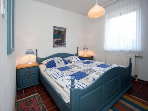 a blue bed in a bedroom with two night stands at Holiday Bungalow in Dornumersiel in Dornumersiel