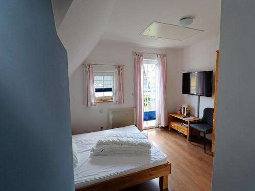 a bedroom with a bed and a desk and a television at Doppelhaushälfte Bernsteinhaus II, Trassenheide in Trassenheide
