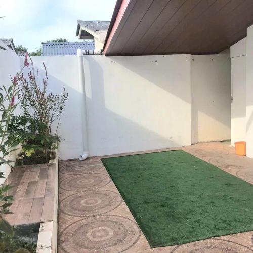 a small garden with a green rug on a patio at Playa Dorada Apartamento con Piscinas, Toboganes y Diversión in Vacamonte