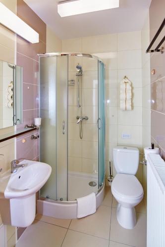 a bathroom with a shower and a toilet and a sink at Centrum Obsługi Turysty Kordegarda in Raczki