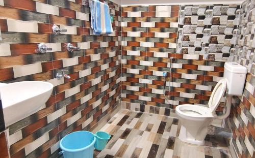 a bathroom with a toilet and a sink at Abhinandan Homestay in Shānti Niketan