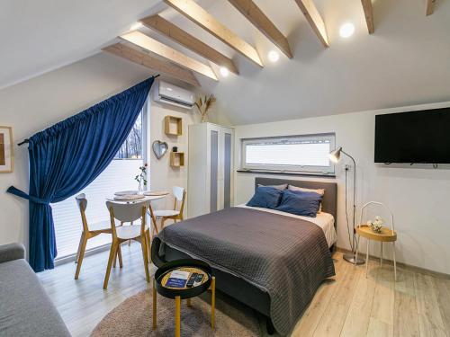 una camera da letto con un letto, un tavolo e una TV di Niechorze Apartment near Baltic Beach a Niechorze