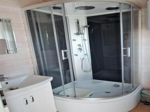 a bathroom with a shower and a sink at Dziwnówek Holiday House near Beach in Dziwnówek