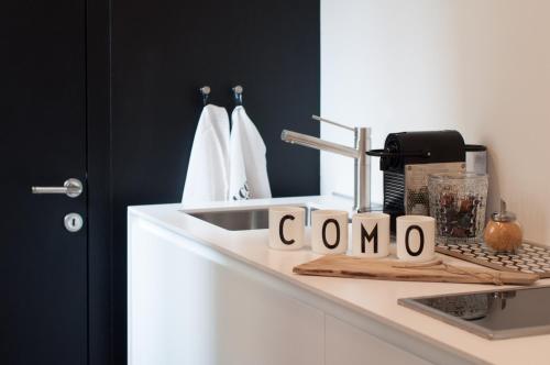 eine Küchentheke mit Spüle und ein Schild mit Como in der Unterkunft Suite Juvara in Como