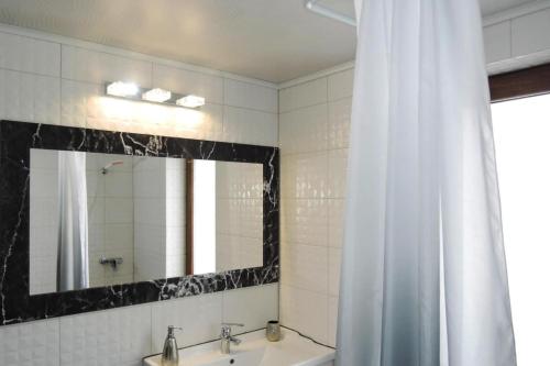 a bathroom with a shower curtain and a sink and a mirror at Seaside Holiday Home winouj cie in Świnoujście