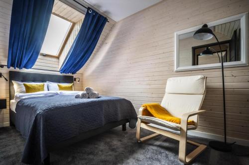 una camera da letto con un letto, una sedia e una finestra di Rewal Cottage near the Baltic Beach a Rewal