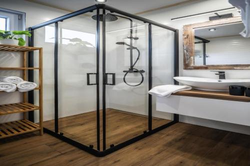 un bagno con doccia in vetro e lavandino di Rewal Cottage near the Baltic Beach a Rewal