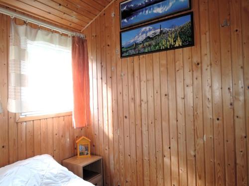 a bedroom with a tv on a wooden wall at Bungalow near the Baltic Sea Beach in Wrzosowo