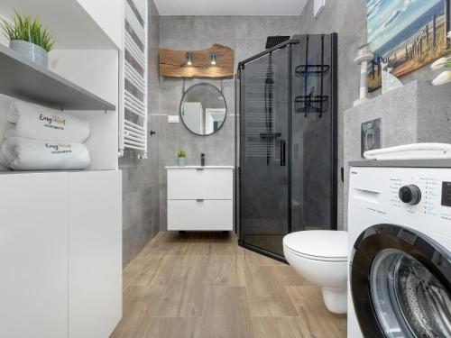レバルにあるHoliday Apartment Rewal Baltic Beachのバスルーム(シャワー、トイレ、洗濯機付)