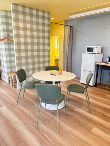 a room with a table and chairs and a kitchen at Vivo House Hakomatsu - Apartment Stay in Fukuoka