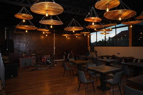 a restaurant with wooden tables and chairs and chandeliers at 999 Lounge Wellawaya in Wellawaya
