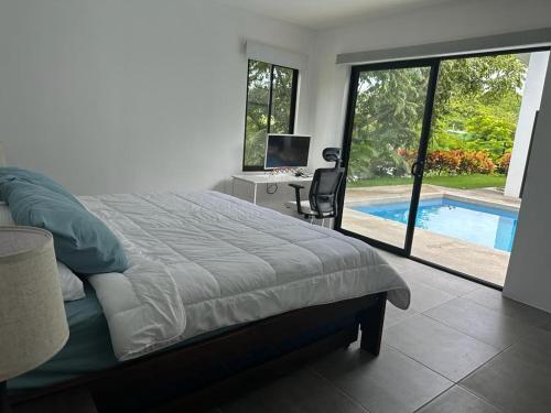 a bedroom with a bed and a desk and a pool at Casa Luna in Santa Cruz