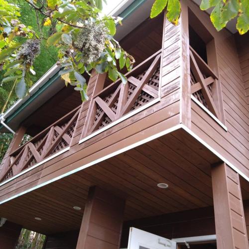 a wooden building with a balcony on top of it at 一棟貸切別荘 神氣龍 in Sagamihara