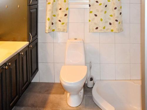 a bathroom with a toilet and a tub and a sink at 8 person holiday home in FREI in Frei