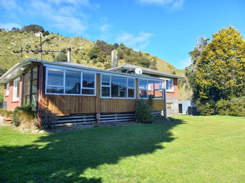 a home with a mountain in the background at Hill top view farm stay in Uruti