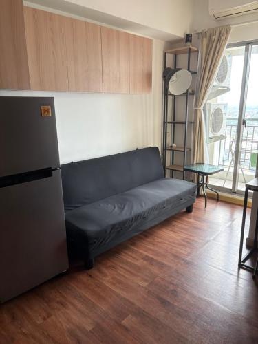 a black couch in a living room with a table at M-town residence cozy apartment gading serpong in Pumpangsineng