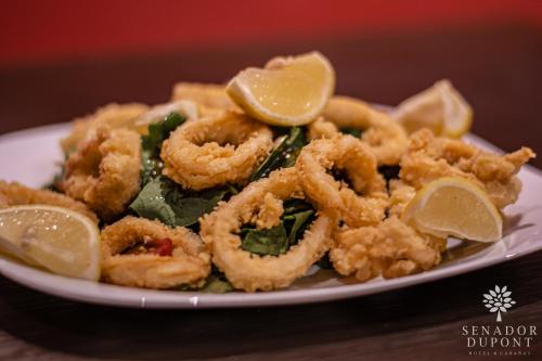 a plate of calamari and lemon slices on a table at Senador Dupont- Convento San Francisco & Arboles in Tigre