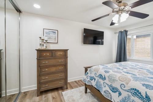a bedroom with a ceiling fan and a dresser at 2 Bed Beach Condo #125 in Carpinteria