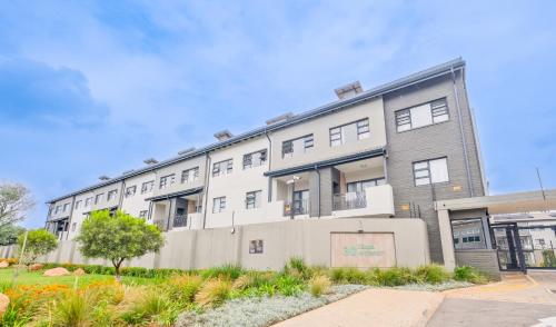 Un gran edificio blanco con muchas ventanas. en SoftPod Loft in Prime Location Fourways, en Sandton