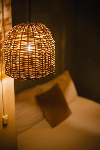 a room with a bed with a lamp and a pillow at THIS IS COLOMBIA HOSTEL in San Gil