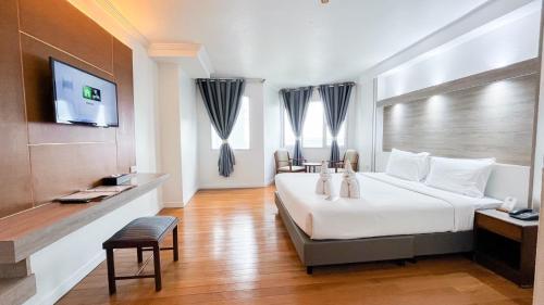 a hotel room with a bed and a television at Thong Tarin Hotel in Surin