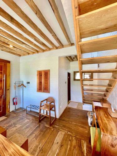 a living room with wooden ceilings and a wooden chair at Eco Wooden Farmhouse in Dieng