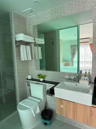 a bathroom with a sink and a toilet and a mirror at Deco 2 in Pattaya North