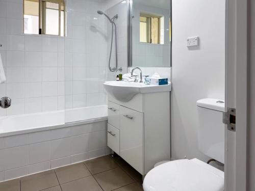 a white bathroom with a sink and a toilet at Bridgewater Rivercity in Brisbane