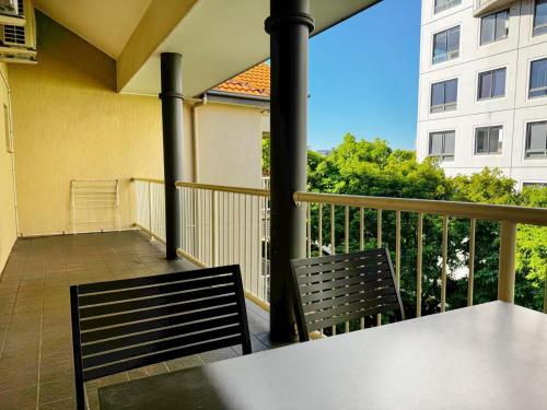 a balcony with a table and two chairs and a building at Bridgewater Rivercity in Brisbane