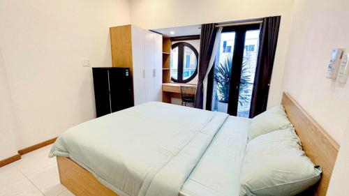 a bedroom with a large bed with a window at Lunaria Maison - Local Side in Ho Chi Minh City