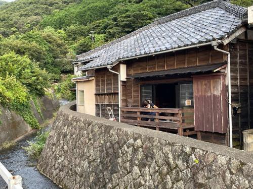 a woman standing on the balcony of a house at TAKUMI-AN Private Ancient House and Garden in Numazu